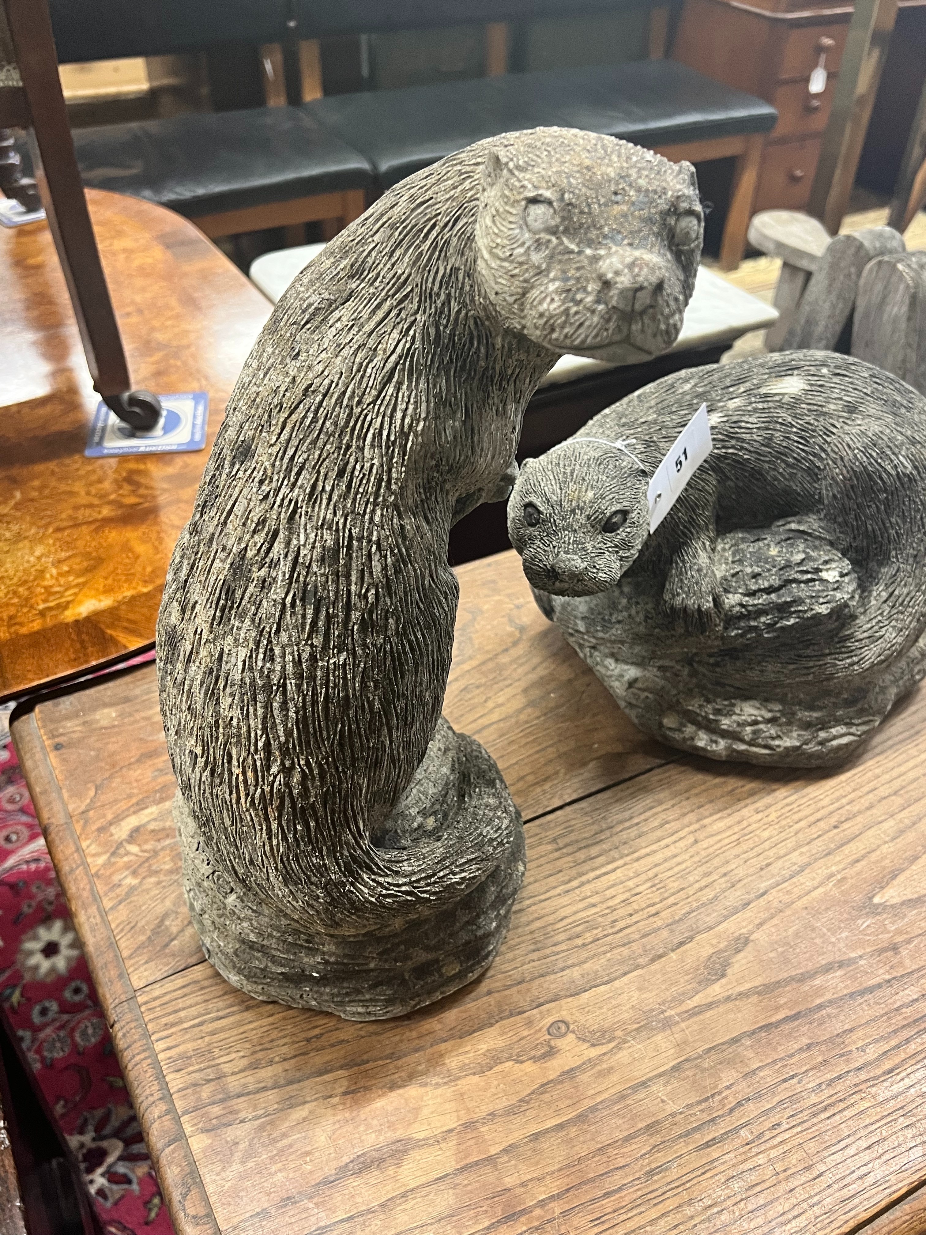 Two reconstituted stone otter garden ornaments, tallest 40cm